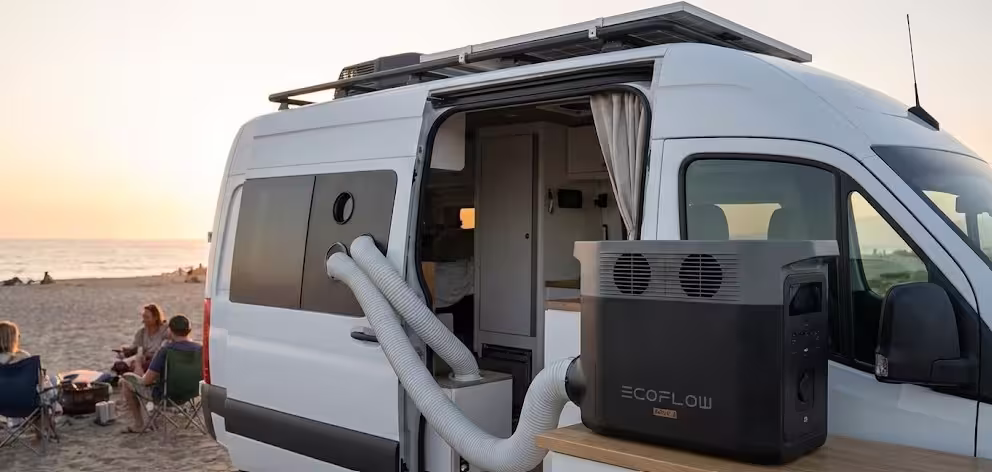 EcoFlow Wave 3 aire acondicionado portátil instalado en el interior de una furgoneta camper con kit de ventana y tubos de evacuación en un entorno de playa.
